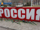 В Донецке приспустили флаги и несут цветы к стеле Россия