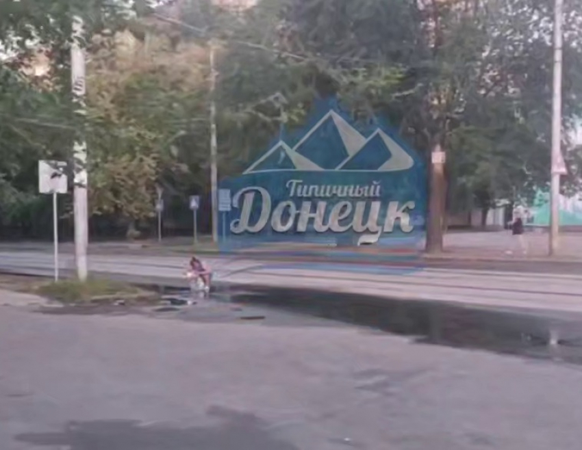 Люди в Донецке набирают воду из луж на дорогах